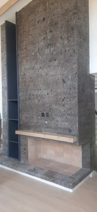 Dark grey smooth stone cladding on a fireplace wall